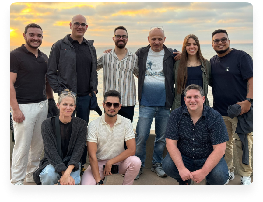 A team image of 9 people with a sunset backdrop - Salespeak Images